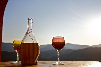 Wine glass on table against sky
