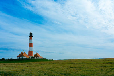 Lighthouse by sea against sky