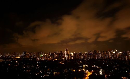 Illuminated cityscape against sky at night