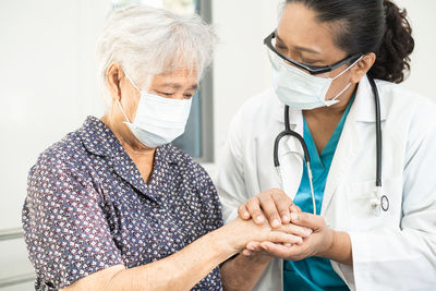 Holding hands asian senior  woman patient with love, care, encourage and empathy  