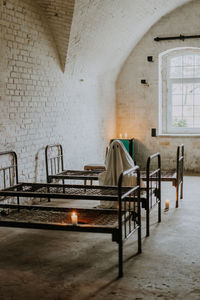 Empty chairs and table against wall in building