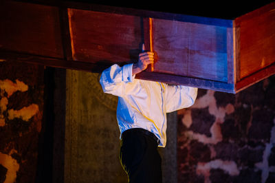 Low angle view of man carrying furniture at night