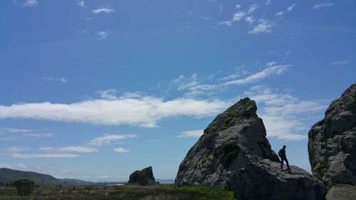 Low angle view of rock formation against sky contemplating the climb