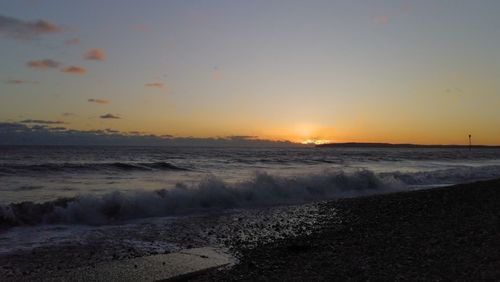 Scenic view of beach against sky during sunset