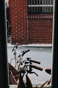 Bicycle parked against brick wall