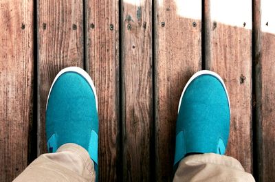 Low section of woman standing on wooden floor