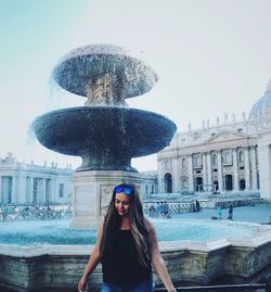 Portrait of woman against fountain against clear sky