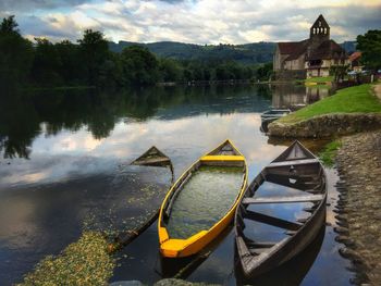 Boats moored on river against trees