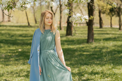 Portrait of young woman standing on garden 