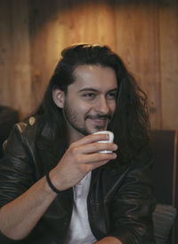 Portrait of young man drinking glass