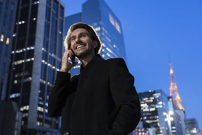 Portrait of businessman standing against clear sky