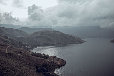 Scenic view of sea and mountains against sky