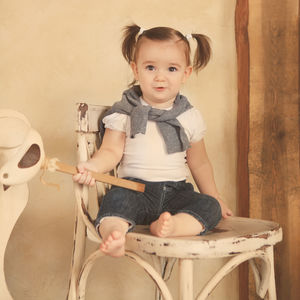 Portrait of cute girl sitting on wall