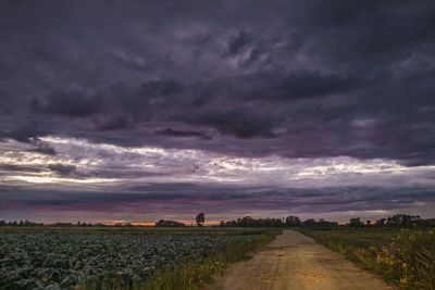 Scenic view of agricultural field against dramatic sky