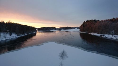 Scenic view of frozen lake against sky during sunset