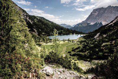 Scenic view of lake by mountains against sky