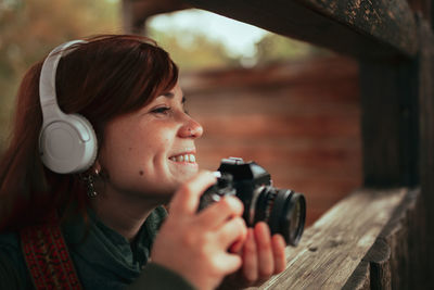 Close-up of woman looking away while photographing outdoors