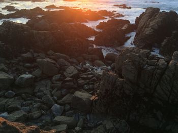 Rocks on beach during sunset