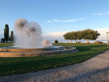 Fountain in park against sky in city