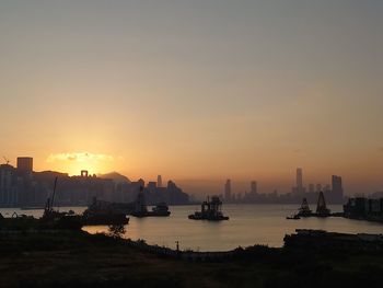 Scenic view of silhouette buildings against sky during sunset