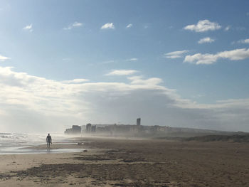 Man standing on beach against sky