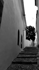 Low angle view of staircase amidst buildings against sky