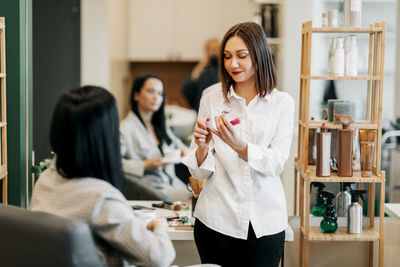 The make-up artist girl selects a lipstick suitable for her client