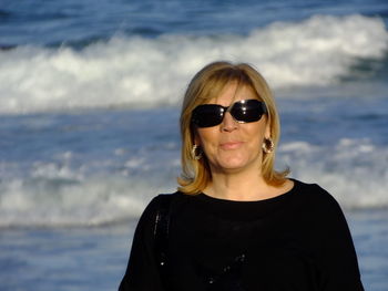 Portrait of woman wearing sunglasses against sea