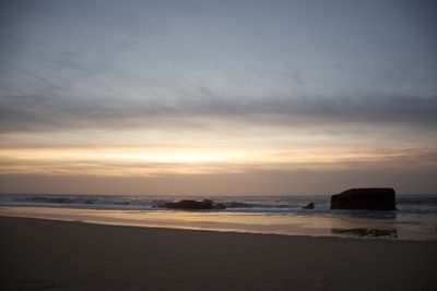 Scenic view of beach against sky during sunset