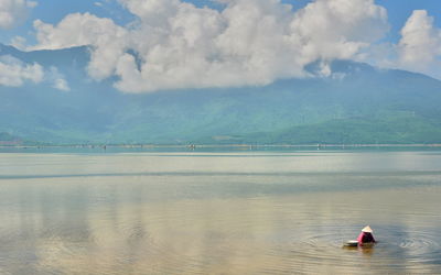 Woman in lake against sky