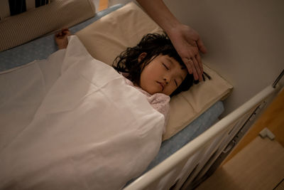 High angle view of boy sleeping on bed at home