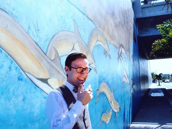 Portrait of young man wearing sunglasses standing outdoors