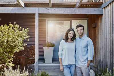 Couple standing in front of door of their home