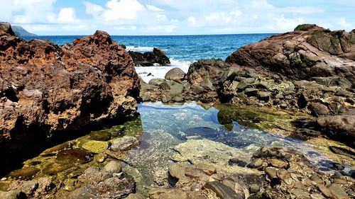 Close-up of rocks in sea against sky