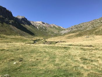 Scenic view of landscape and mountains against clear blue sky