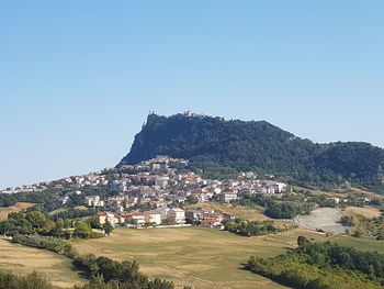 Houses on mountain against clear blue sky