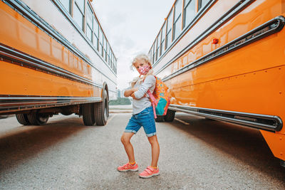 Portrait of girl standing against bus