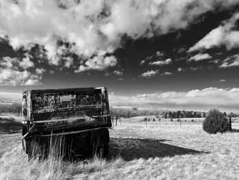 Abandoned truck on field against sky