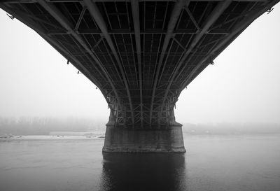 Low angle view of bridge over river against sky