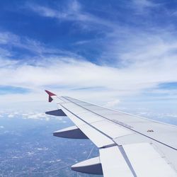 Airplane flying over clouds against blue sky
