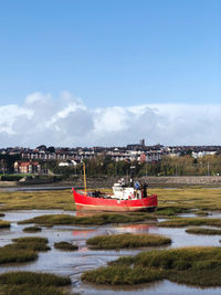 Scenic view of river by buildings against sky