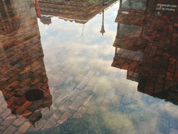 High angle view of buildings reflection in puddle