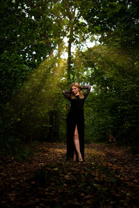 Full length of woman standing in forest