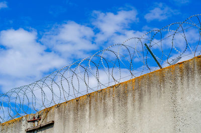 Barbed wire fence on high wall. protection of important object.