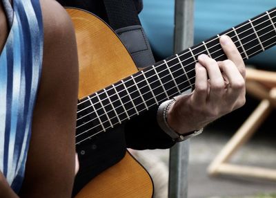 Cropped hand of man playing guitar