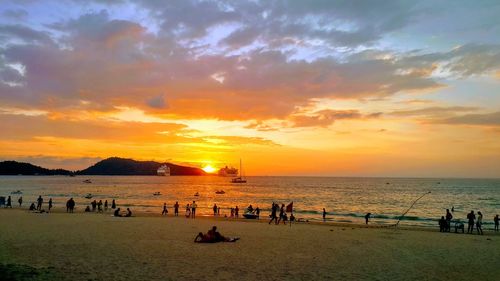 Group of people on beach at sunset