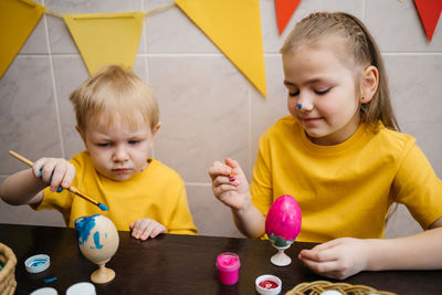 Brother and sister color easter eggs