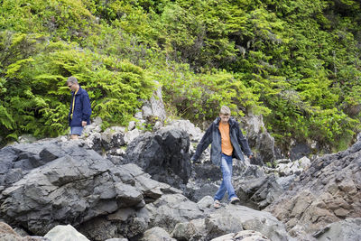 People on rocks against trees