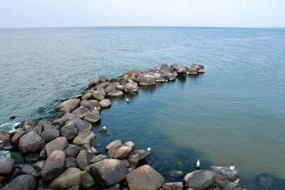 Rocks in sea against clear sky