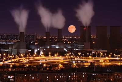 Illuminated cityscape against sky at night